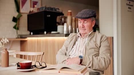 elderly man reading in a coffee shop