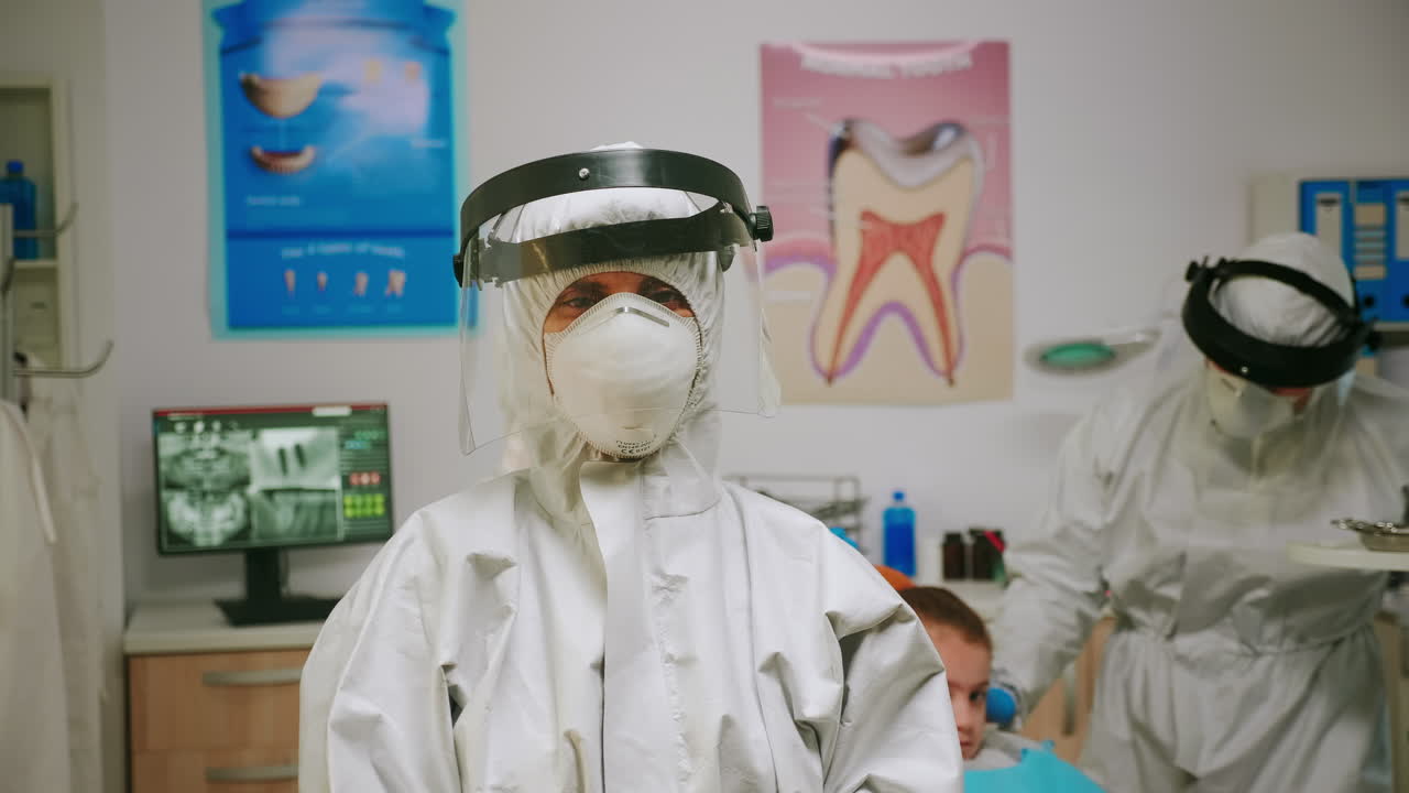 retrato de una mujer estomatóloga cansada con un abrigado y un escudo facial