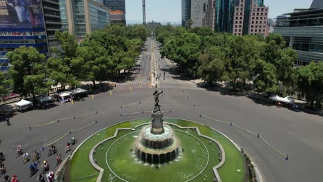 static drone shot of fuente de la diana cazadora while cyclists exercise in mexico city