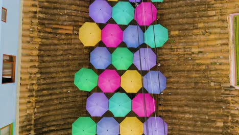 top down view of colorful umbrellas above city street in guatape, colombia