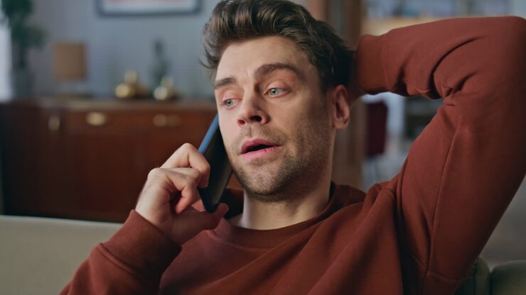 ein entspannter geschäftsmann ruft am wochenende zu hause zum handy an.