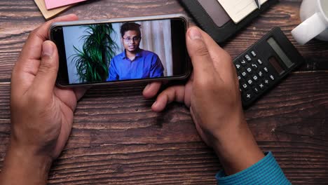 video call on smartphone at office desk