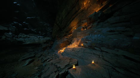 candles illuminate rocky cave formations during a serene night gathering