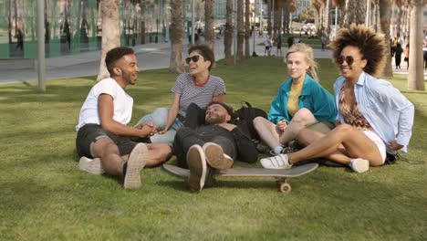 laughing diverse friends chilling in park