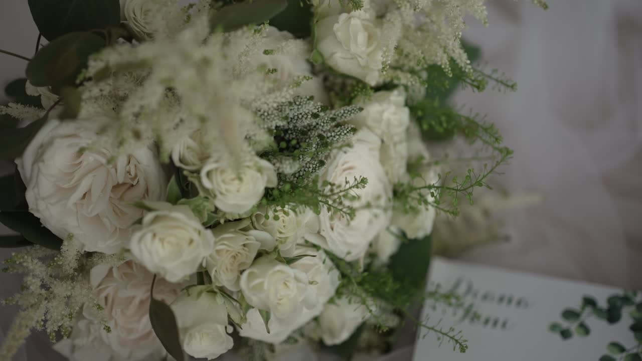 lush white floral bouquet with a mix of roses and greenery, elegantly arranged