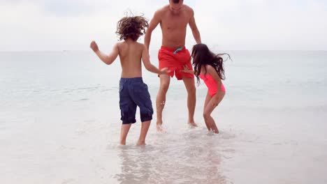 Padre-E-Hijos-Saltando-En-El-Mar