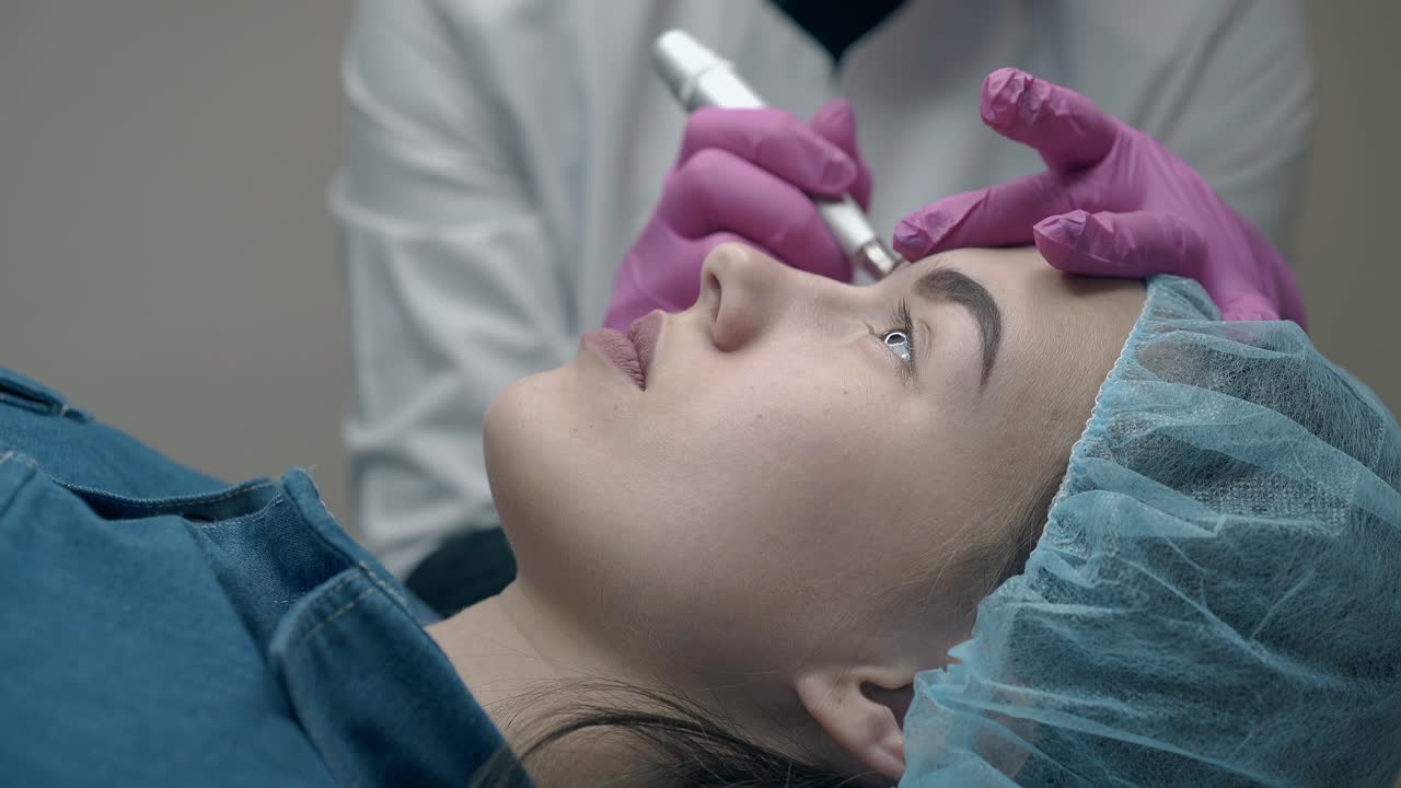 cosmetician con abrigo blanco y guantes estériles aplica maquillaje