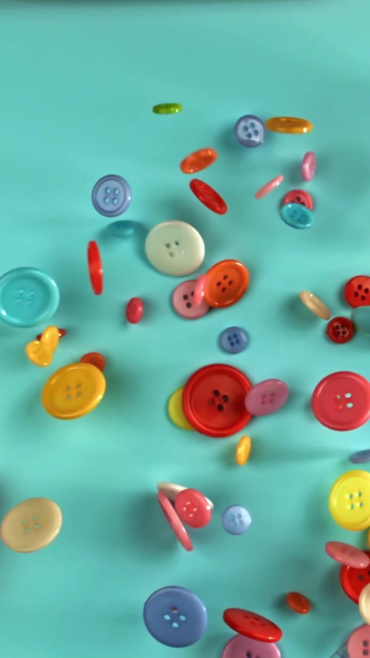 Bottoni Colorati che Cadono su uno Sfondo Blu