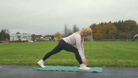 mujer practicando yoga de baja longitud al aire libre