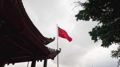 vietnamese flag waving near traditional architecture