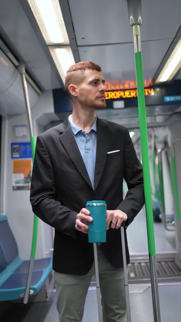 A man riding the subway with a cup and suitcase