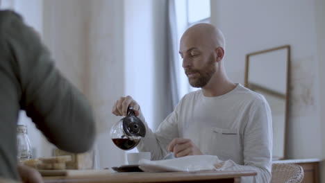 cute homosexual man having breakfast with his partner in morning