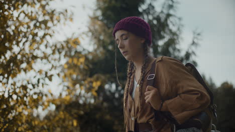 woman with braided hair wearing knitted hat in forest