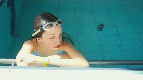 Eine-Junge-Frau-Ist-In-Einem-Pool-Zu-Sehen,-Wo-Sie-Sich-Nach-Dem-Schwimmen-Entspannt