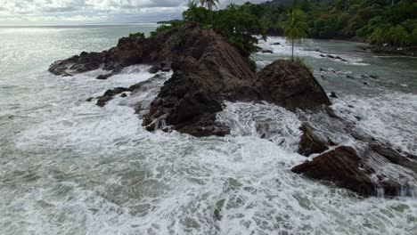 Aerial-Dolly-Beim-Fliegen-über-Schäumende-Meereswellen,-Die-Felsige-Küste-In-Der-Nähe-Von-Waldhängen-In-Dominicalito-Beach,-Costa-Rica,-Treffen