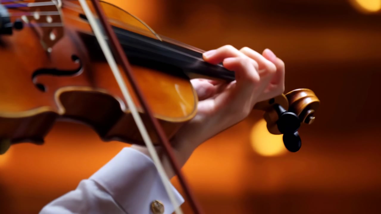 Un sereno violinista suona musica classica in una sala da concerto, ripreso in una vista laterale ravvicinata con un archetto di legno e uno strumento a corda. La scena è ambientata su uno sfondo bianco e aub.