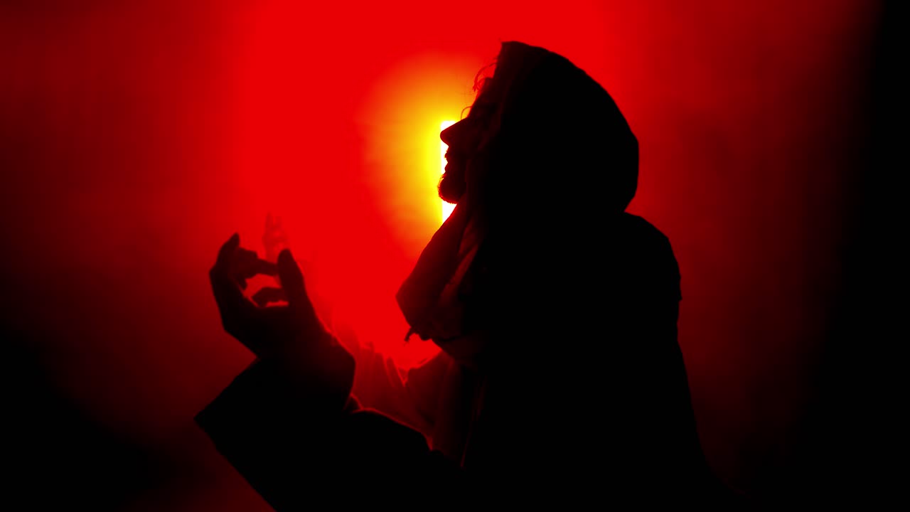 Dramatic, stylistic silhouette of Jesus Christ praying in Red Light for Christianity, Easter visual, bible scene or temptation, prayer, worship visual.