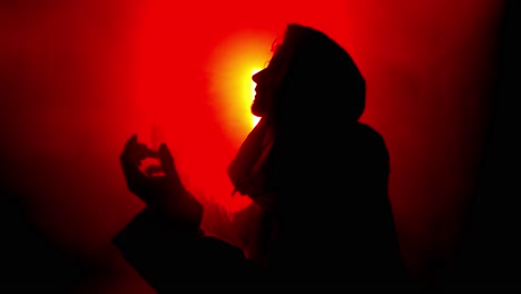 dramatic, stylistic silhouette of jesus christ praying in red light for christianity, easter visual, bible scene or temptation, prayer, worship visual.