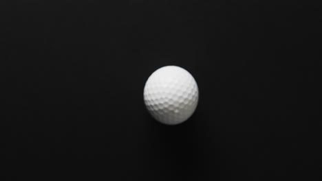 Close-up-of-golf-ball-on-black-background,-copy-space,-slow-motion