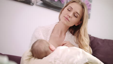 Beautiful-mom-breastfeeding-baby.-Dreamy-mother-breastfeeding-daughter