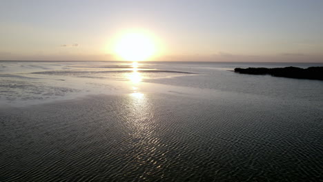 vista de tiro de drone de la isla de agua de playa con cielo de puesta de sol