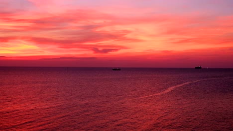 dramatic sunset seascape pink and orange sky twilight view with silhouette oil tanker ship from koh sichang, chon buri, thailand, uhd 4k video with copy space