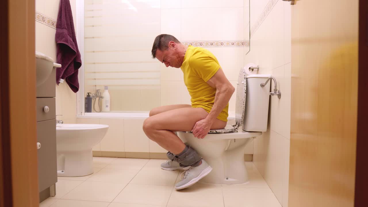 Man struggling with great constipation on toilet