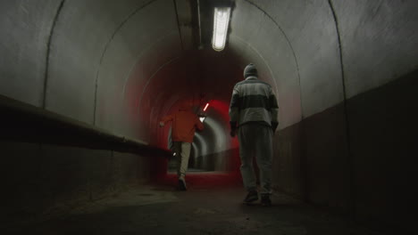 parkourists freerunning in dark tunnel