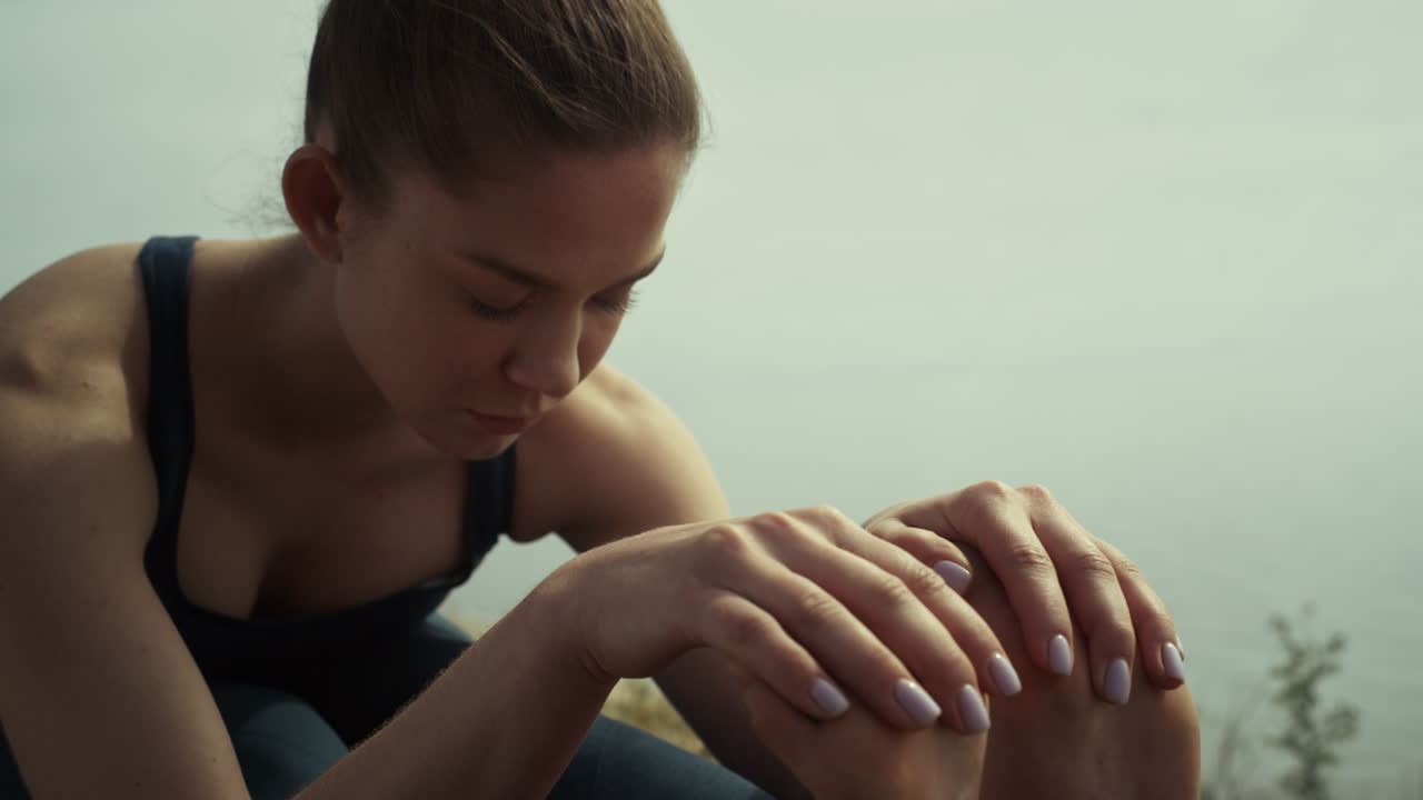 mujer de yoga haciendo ejercicios en la playa de cerca. chica relajada estirando el cuerpo.