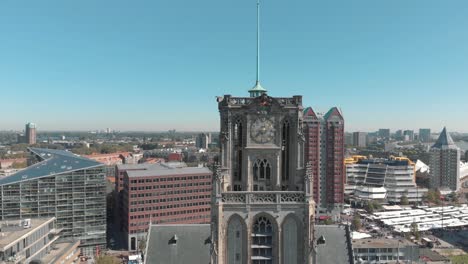 aerial drone footage rising along the face of a church tower, revealing the city of rotterdam, netherlands