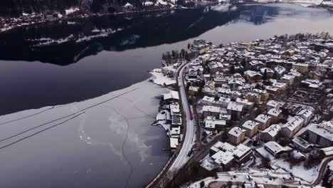 Sensationelle-Luftaufnahme-Des-Zeller-Sees-Und-Der-Stadt-Mit-Vorbeifahrendem-Zug