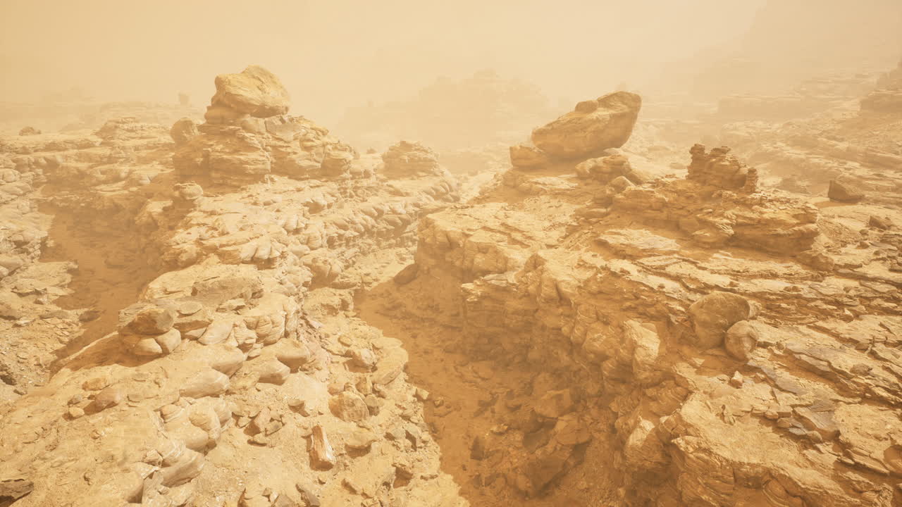 Sandy landscape with rocky formations under a dust storm in a desert area