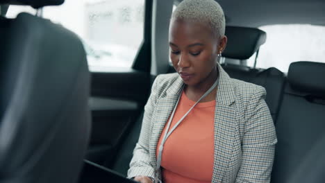 a woman working on a tablet in the back seat of a car