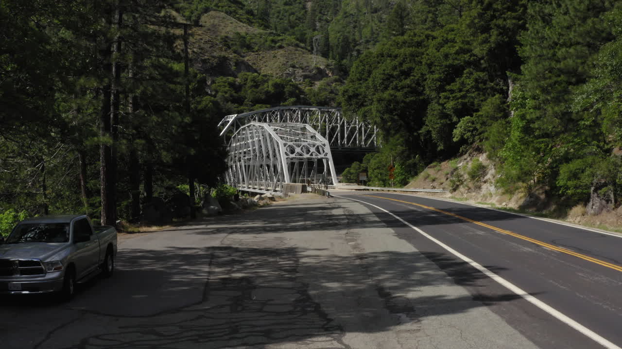 Flying backwards on side of road with Pulga Bridges in background, Plumas National Forest, aerial