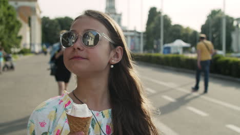 Chica-Relajada-Caminando-En-El-Parque-De-Diversiones.-Jovencita-Comiendo-Cono-De-Helado