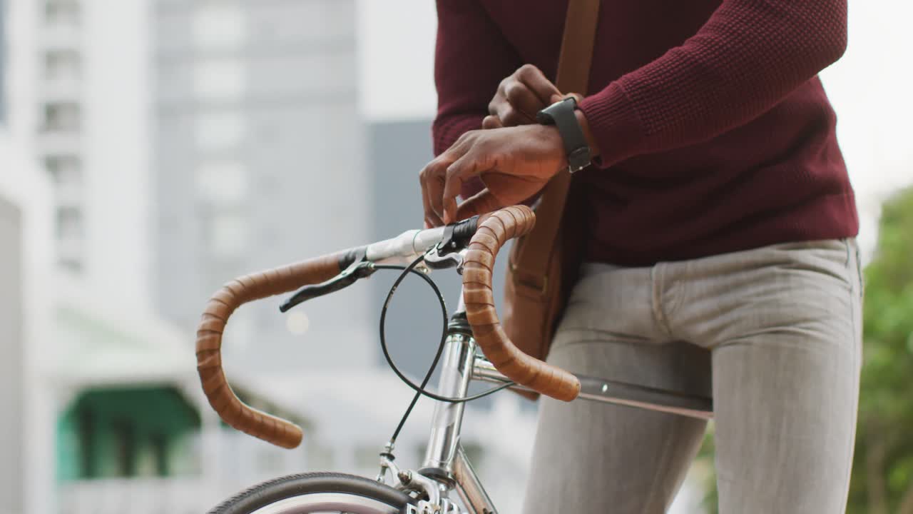 아프리카계 미국인 남자가 거리에서 스마트워치를 사용하고 있다