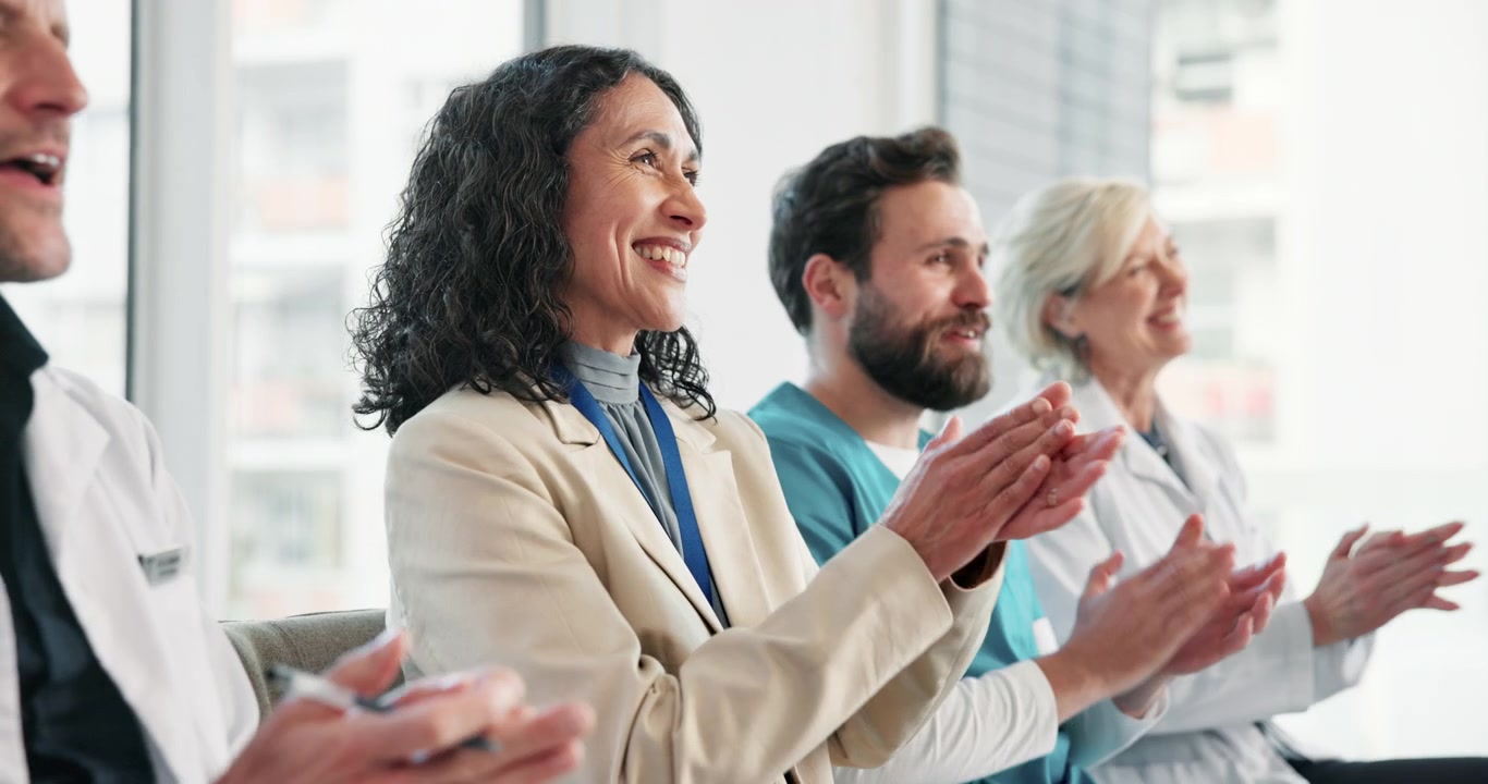 Diverse Group of Medical Professionals Applauding During a Conference