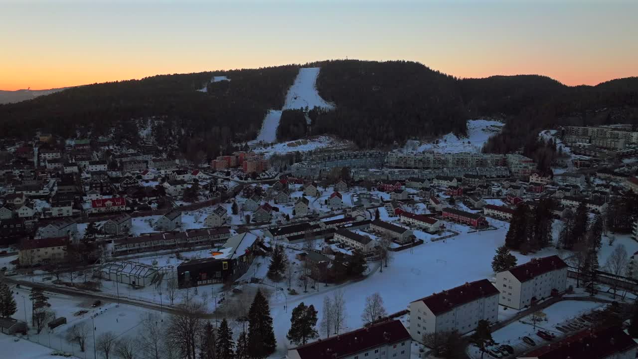 Winter dusk sunset Oslo Skisenter ski resort trails mountain Norway Norge aerial drone Tonsenhagen Bjerke Norwegian downtown city arctic winter vibrant buildings snow Nordmarka forest upwards