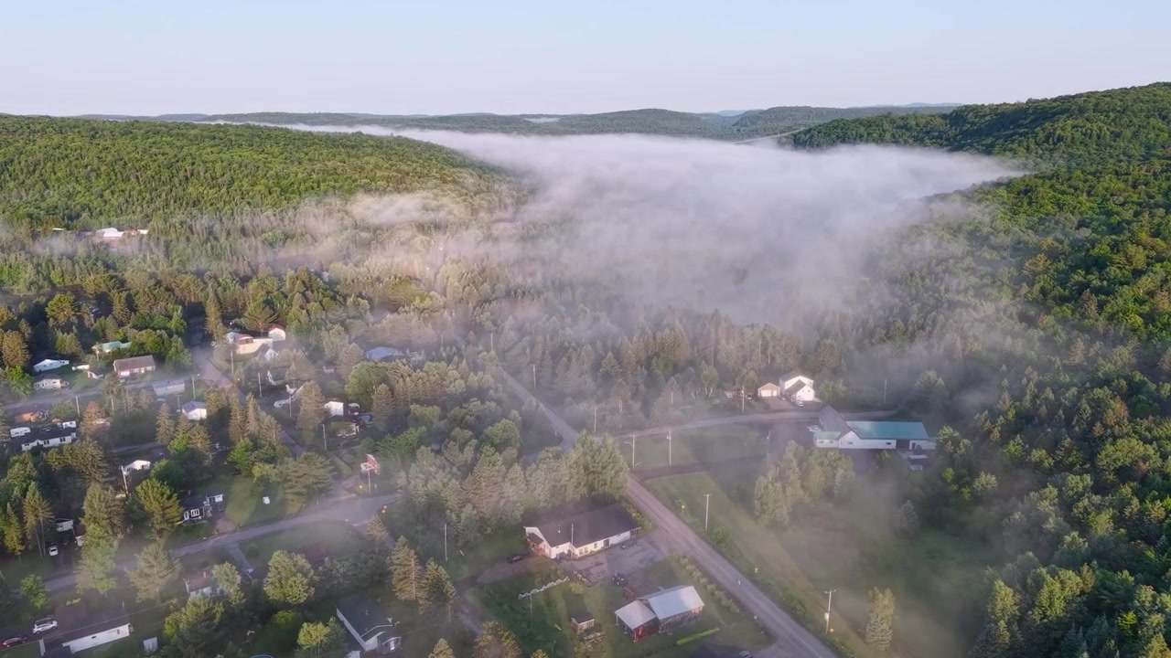 Nebbia bassa sulla cittadina di Rawdon, Quebec, Canada, circondata da foreste verdi