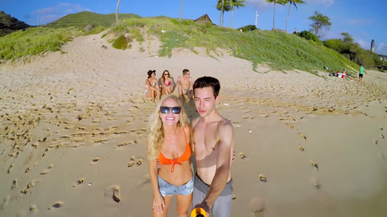 Turistas tomándose una selfie en la playa 4k