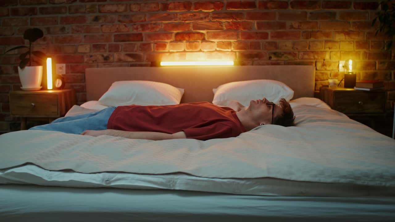 밤에 침대에서 자고 있는 남자