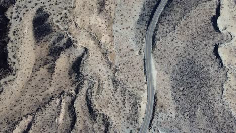 california desert road with few vehicles passing by, aerial top down shot