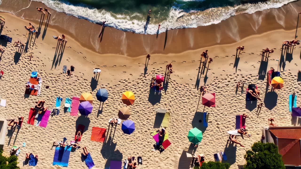 Aerial view of a crowded beach with people, umbrellas, and ocean waves