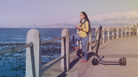 manchas de luz contra la mujer afroamericana teniendo un bocadillo en el paseo marítimo