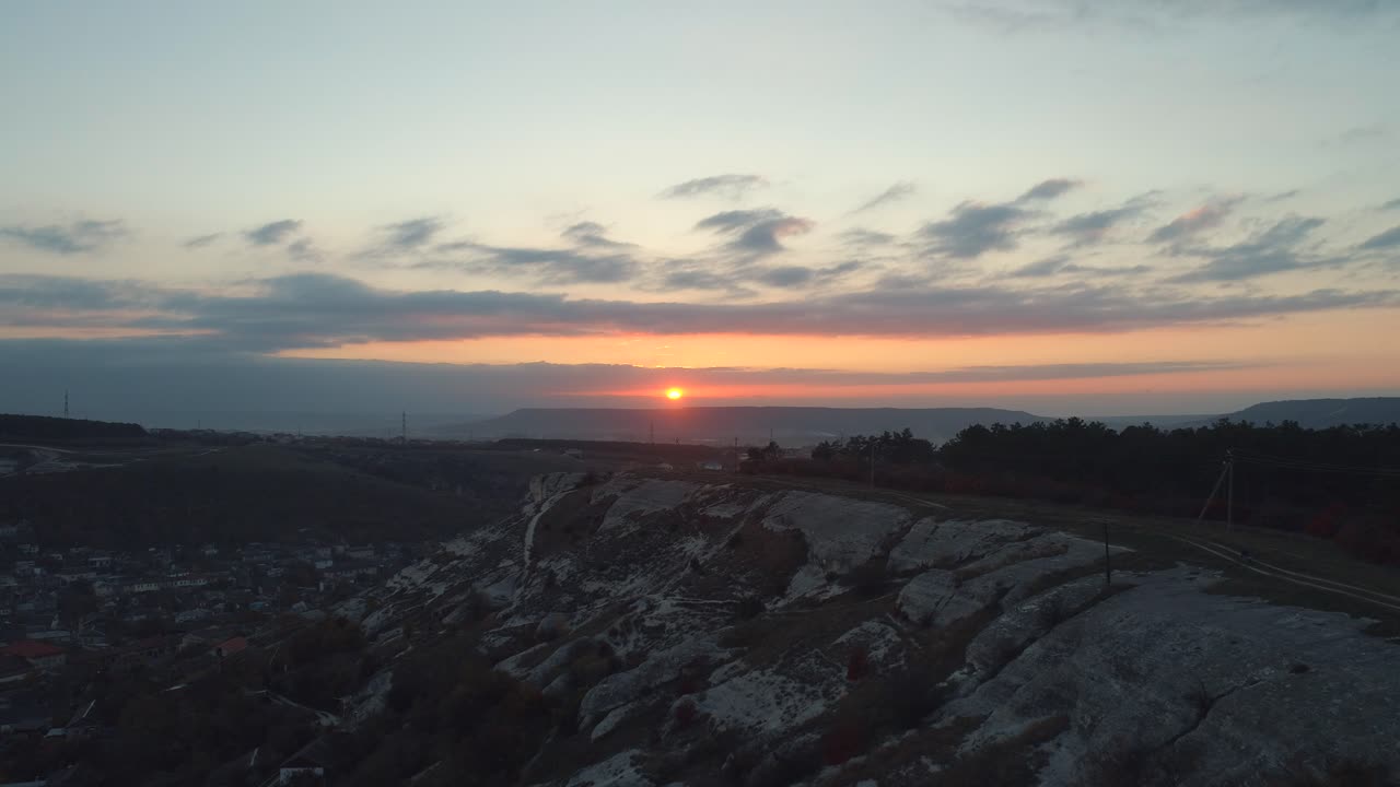 amanecer sobre un paisaje montañoso con vistas a la ciudad