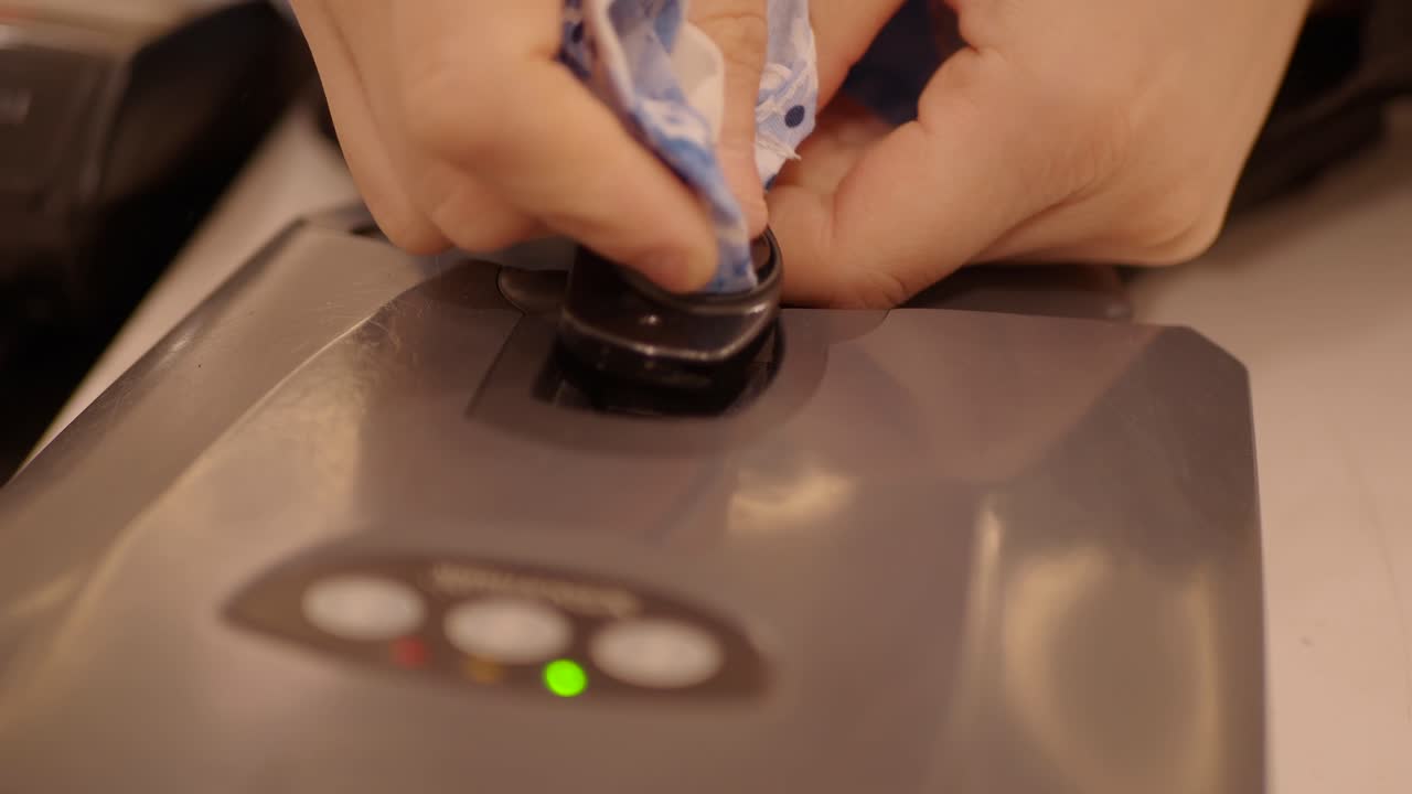 Close-up of a grey electronic device with a green indicator light