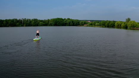 sup surfer on board. drone shot of young man stand up paddling on vacation