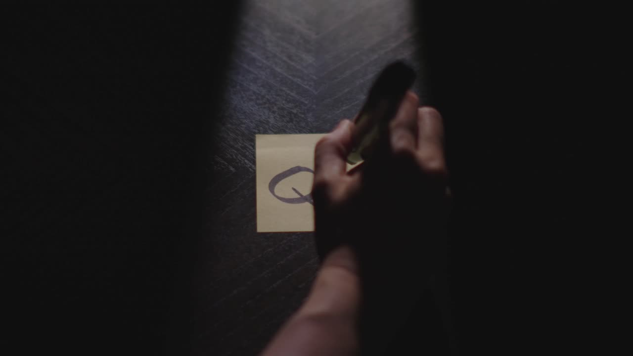 "Q4" written on a Sticky Note with a sharpie and placed on a table under dramatic lighting