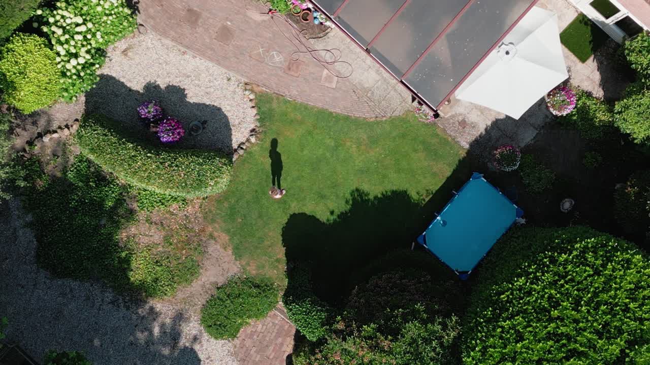 A young little girl doing a handstand exercise in the backyard of her home, Top down aerial view
