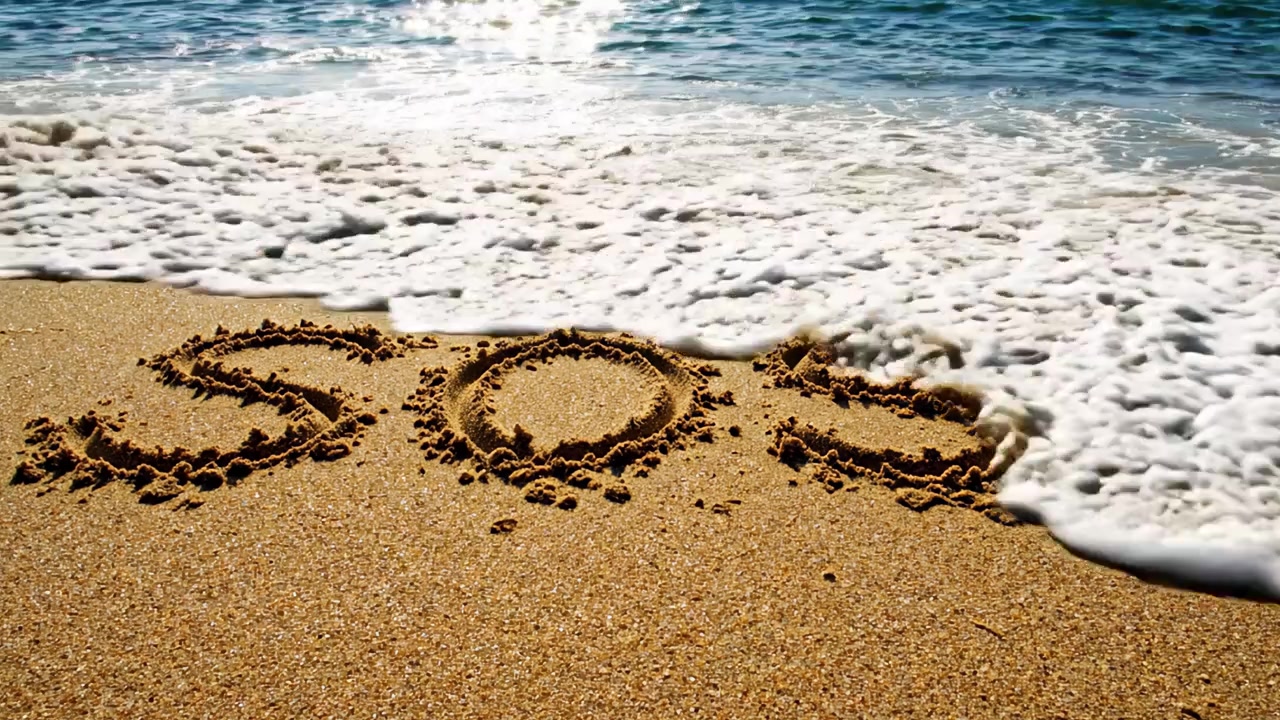 Un messaggio di soccorso: SOS scritto sulla sabbia di una spiaggia mentre le onde si infrangono dolcemente, simboleggiando urgenza e speranza di salvataggio nella serenità naturale